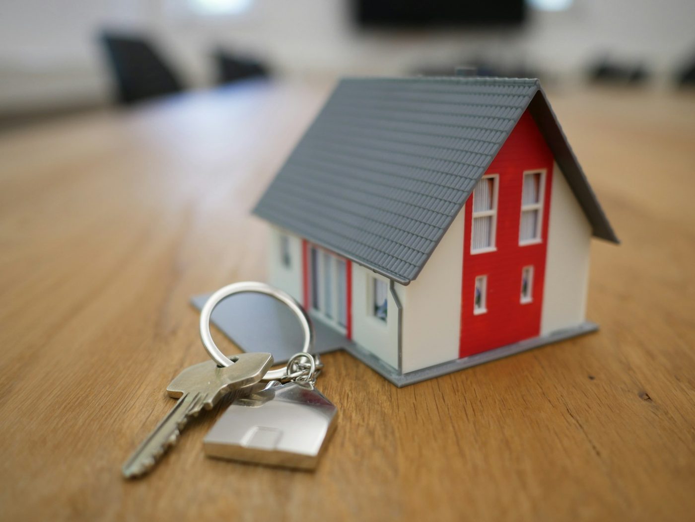 Miniatura de casa com chaves sobre a mesa — consórcio de imóveis